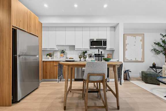 A modern kitchen with a wooden table and chairs.
