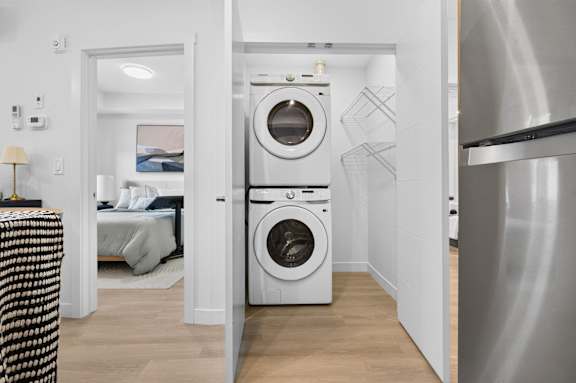 A modern laundry room with a washer and dryer built into the wall.