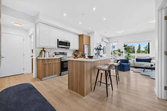 A modern kitchen with wooden cabinets and a bar area.