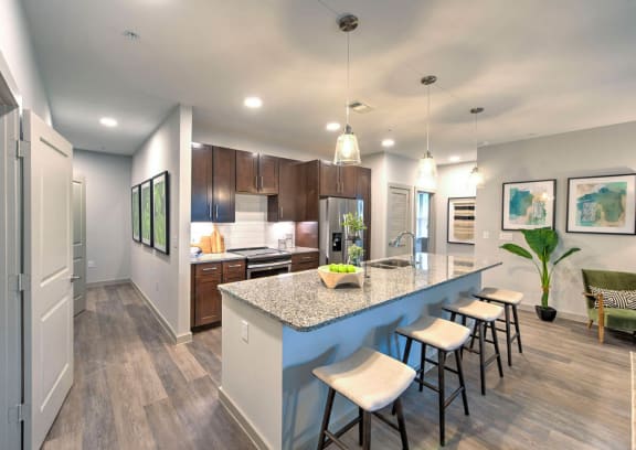 a kitchen with a large island with a breakfast bar at The Pointe at Valley Ranch Town Center, New Caney, TX, 77357