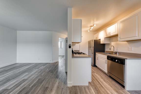 A kitchen with white cabinets and a black refrigerator.