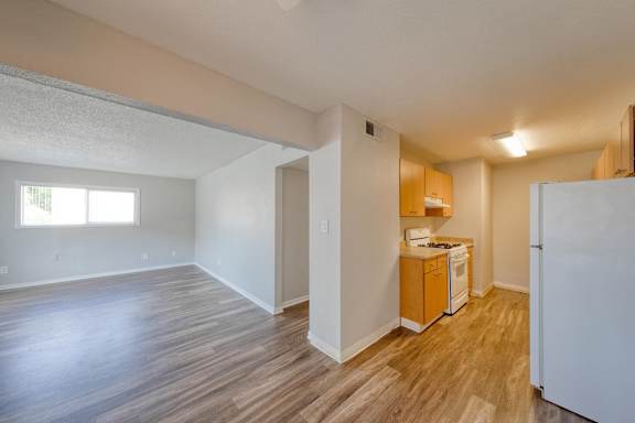 A kitchen area with a refrigerator, sink, and cabinets.