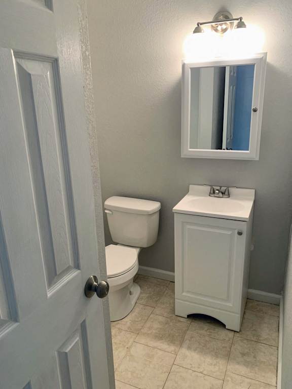 A white toilet and sink in a bathroom.
