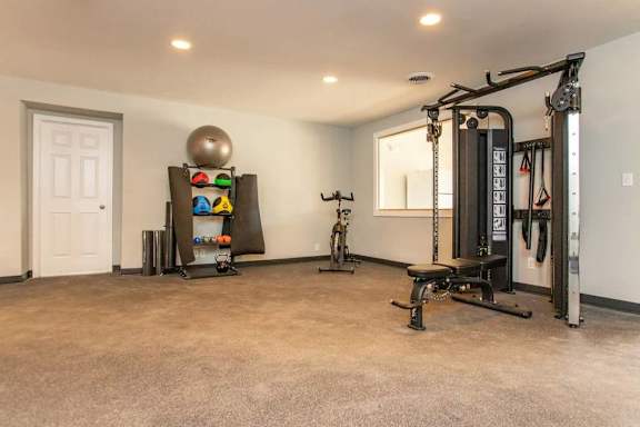 A spacious home gym with a variety of exercise equipment.