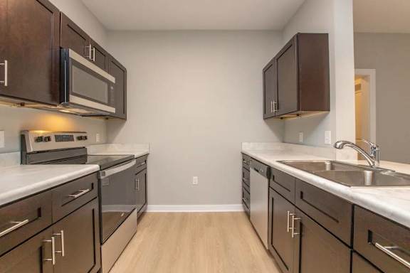 A kitchen with brown cabinets and white countertops.