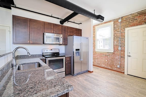 A kitchen with a sink, stove, and refrigerator.