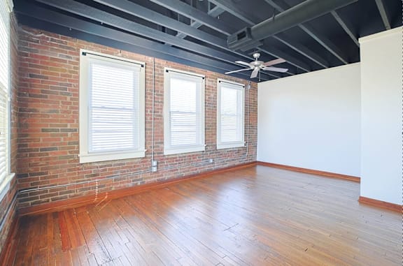 A room with a brick wall and wooden floors.