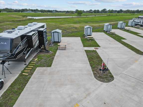 A row of portable toilets are lined up on a concrete path.