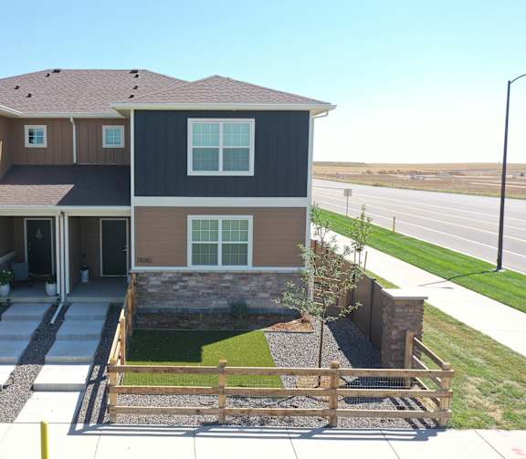 the front of a house with a yard and a fence