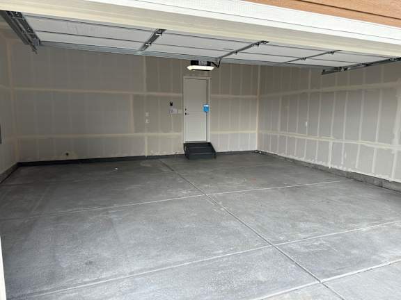 the inside of a garage with a cement floor and a door