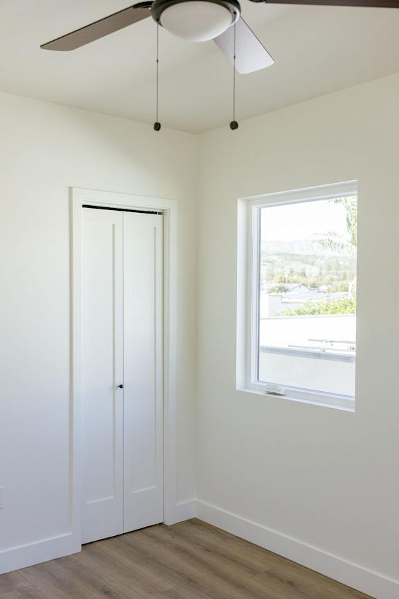 A room with a ceiling fan and a window.