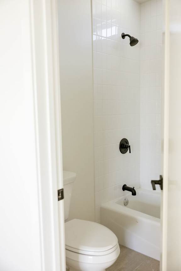 A white toilet and bathtub in a bathroom.