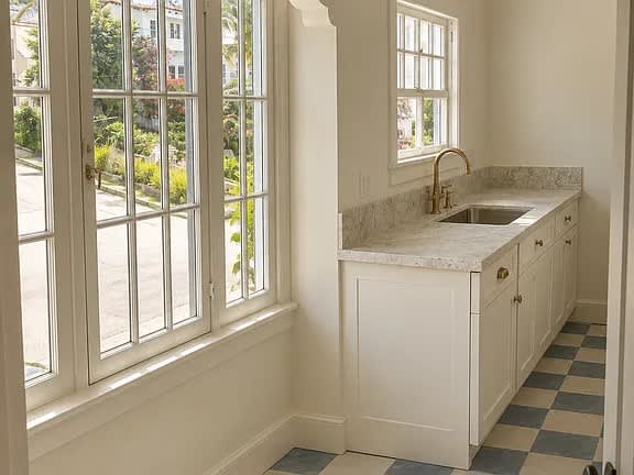 A kitchen with a checkered floor and a window.