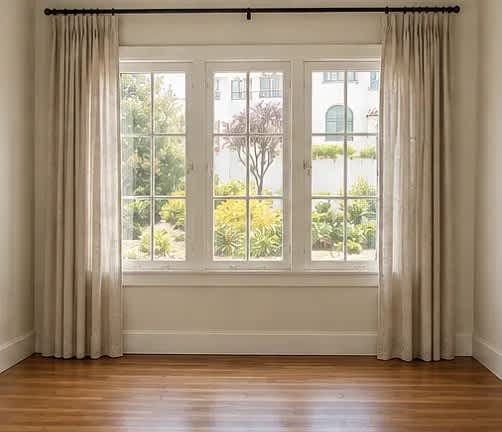 A room with a large window and curtains.