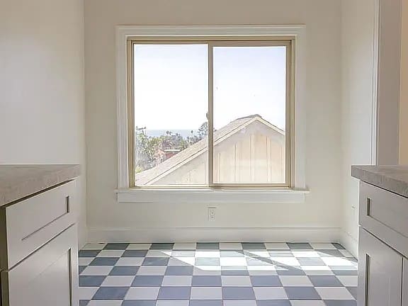 A room with a checkered floor and a window.
