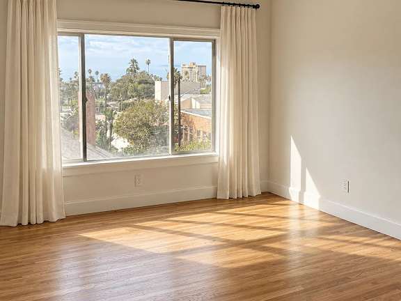 A room with a large window overlooking a cityscape.