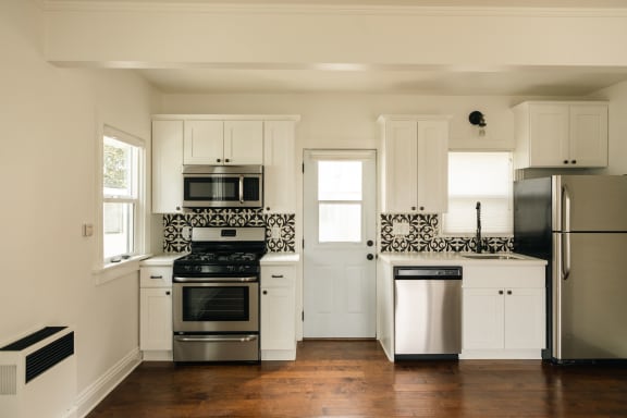 a kitchen with white cabinets and stainless steel appliances