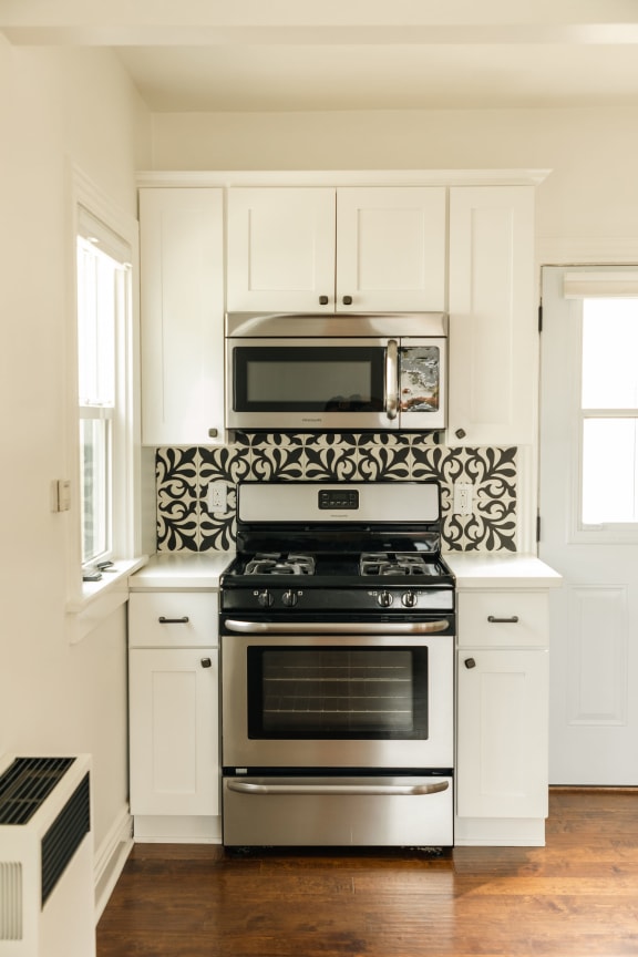 a kitchen with white cabinets and stainless steel appliances