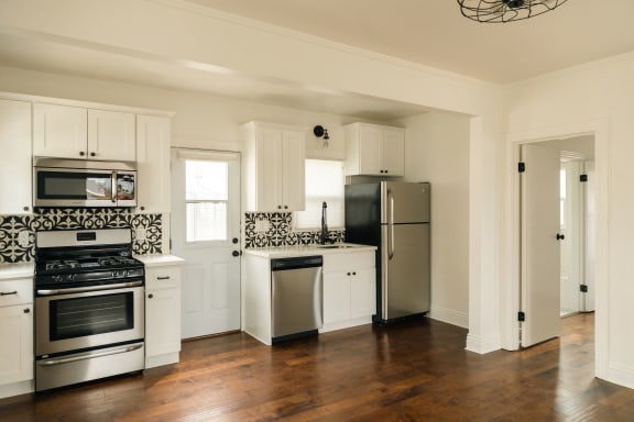 a kitchen with white cabinets and stainless steel appliances