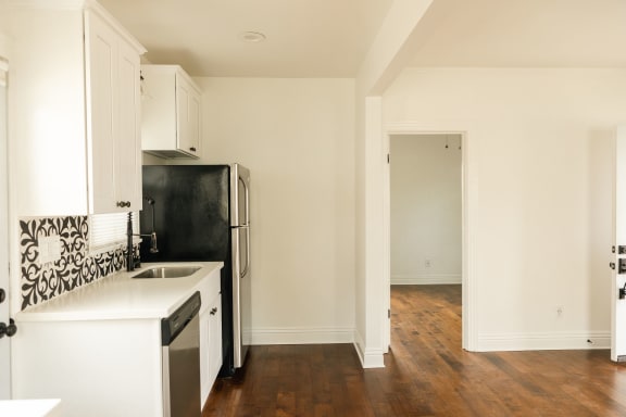 a kitchen with white cabinets and a black refrigerator