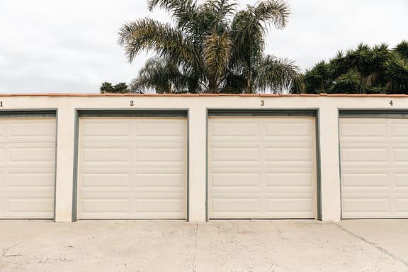 a row of garages with palm trees in the background