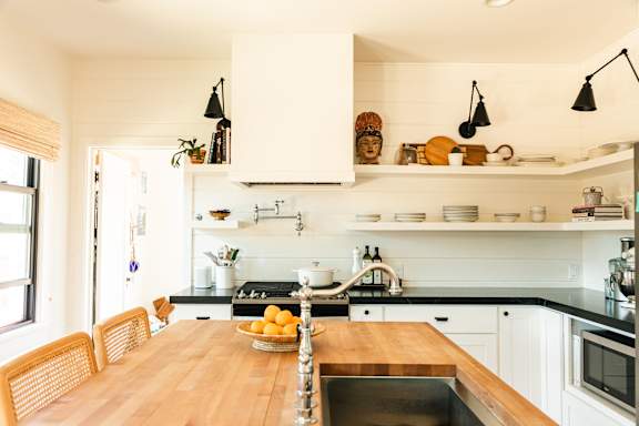 A kitchen with a wooden table and chairs.