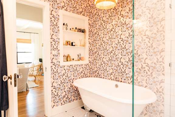 A white bathtub with a glass shower door in a bathroom.