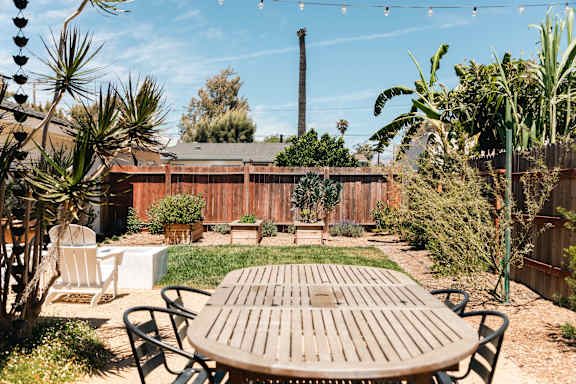 A backyard with a picnic table and chairs.