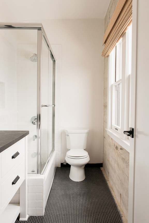 A white toilet in a bathroom with a walk-in shower.