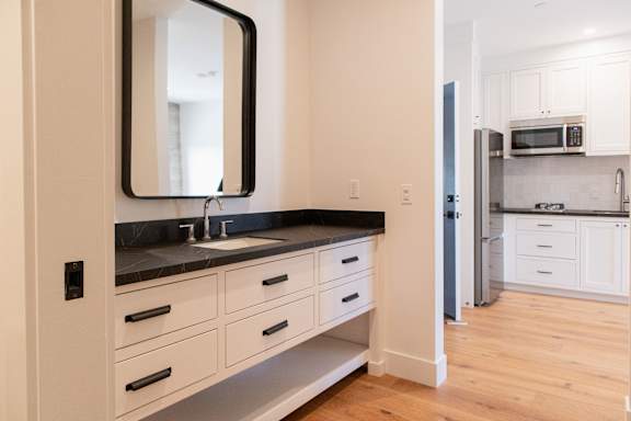 A kitchen with a sink and a mirror on the wall.
