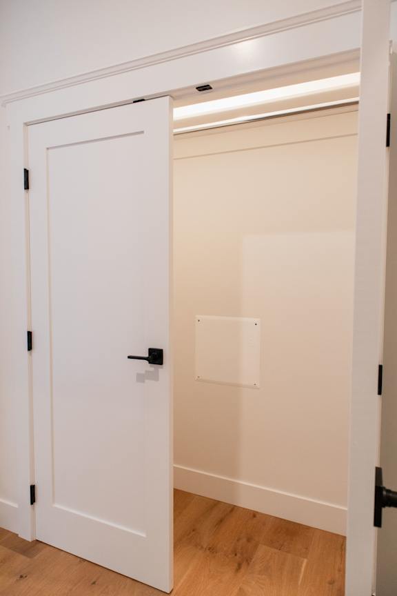 A white door with a black handle is open.