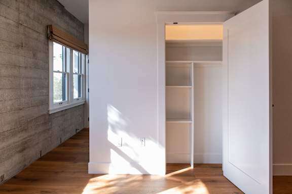 A room with a white wall and a wooden floor.