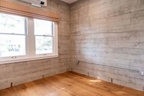 A room with a window and wooden flooring.