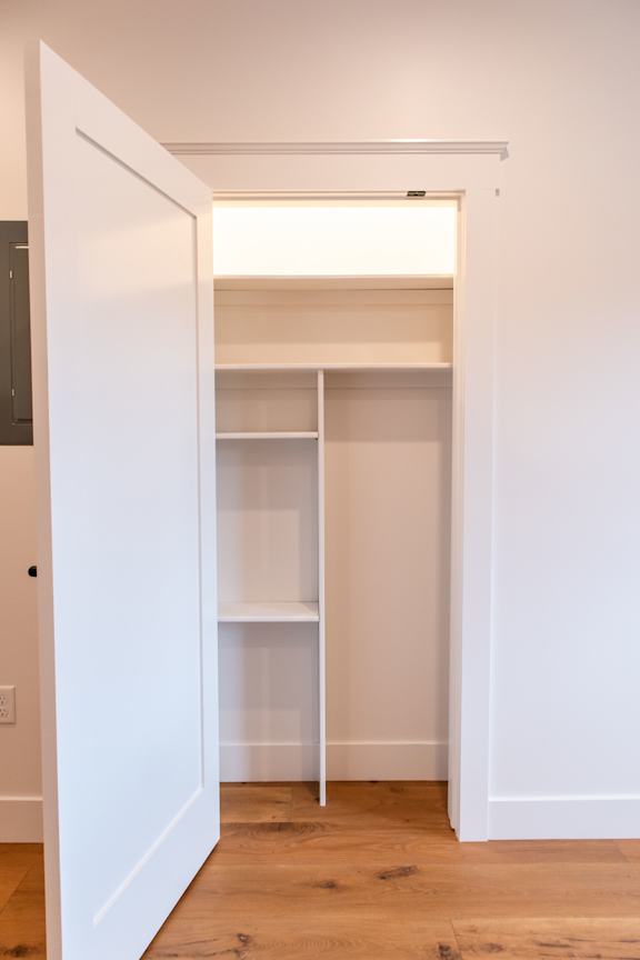 A white doorway leads to a room with a shelf.