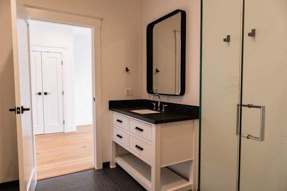 A bathroom with a sink, mirror, and a white cabinet.