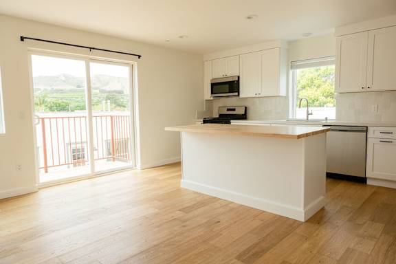 A kitchen with white cabinets and a wooden island.