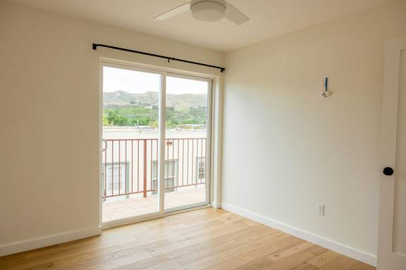 A room with a sliding glass door leading to a balcony.