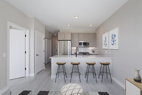 a kitchen with a large island with four stools in front of it at Platform 4611, Chicago, IL
