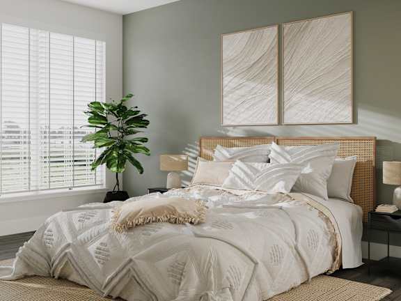 a bedroom with a bed with white sheets and pillows