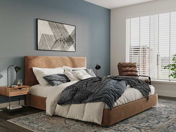 a bedroom with a bed and a chair and a rug