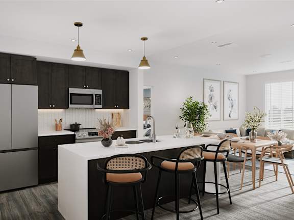 a kitchen with a large island and a dining room with chairs