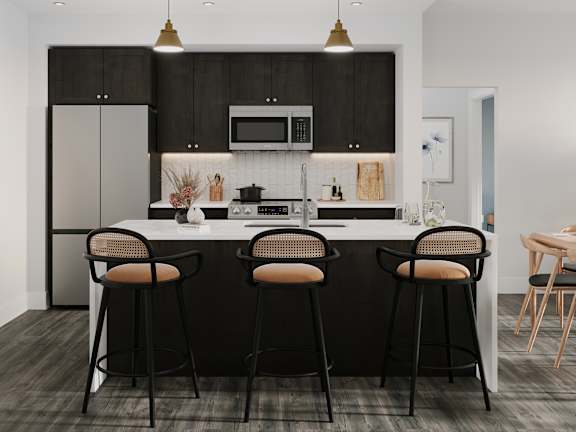 a kitchen with black cabinets and a island with bar stools
