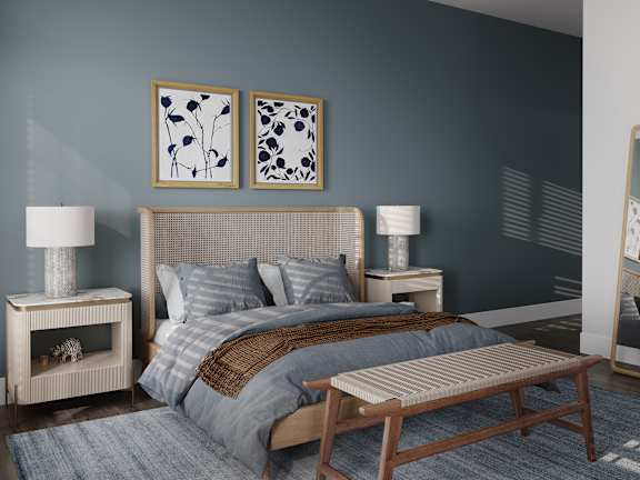 a bedroom with a bed and two paintings on the wall