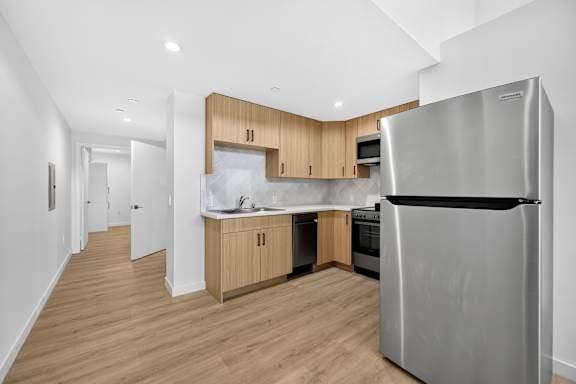 A modern kitchen with a refrigerator on the right.