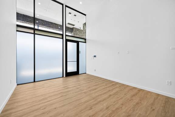 A room with a wooden floor and a glass door.