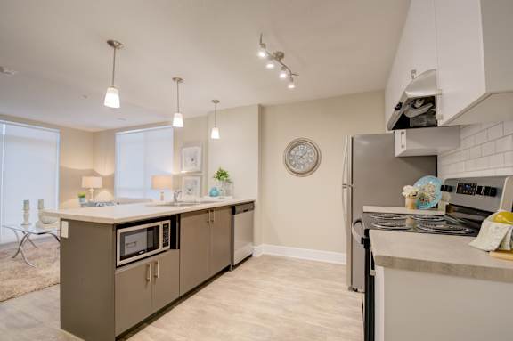 A modern kitchen with a large island and a stove top oven.