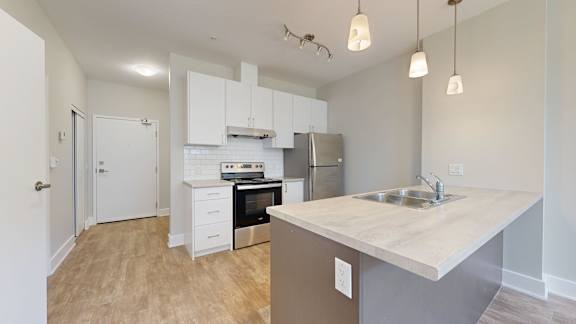 A kitchen with a white countertop and stainless steel appliances.