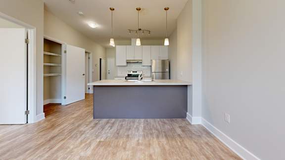 A kitchen with a wooden floor and a grey counter.