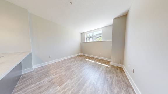 A room with wooden flooring and a window.