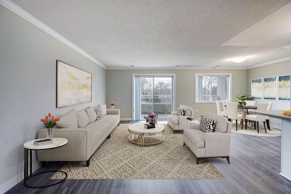 A living room with a couch, chairs, and a coffee table.